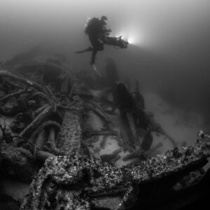 Black and white diver above tangled wreck machinery and plates, Saint-Malo, Brittany, France