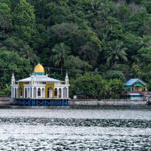 White and gold domed mosque on the waterfront below the jungle, Banda Islands, Banda Sea, Indonesia