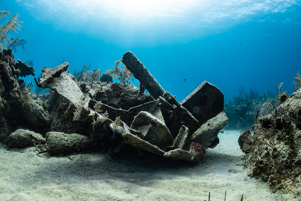 Débris d’épave tordus sur le sable entre des massifs récifaux sous les rayons du soleil, Grand Bahama, Bahamas