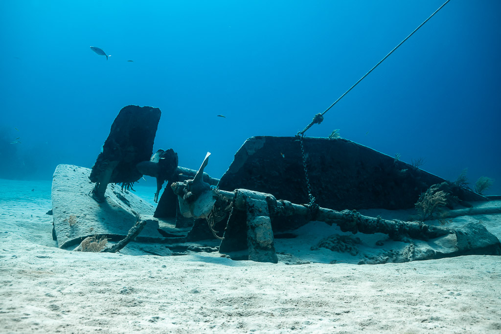 Stern of a broken wreck with rudder, shaft and mooring line on sand, Grand Bahama, Bahamas