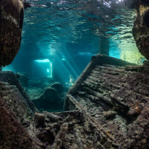 Wreck interior framed by encrusted structures, light rays in distance, SS Sapona wreck, Bimini, Bahamas