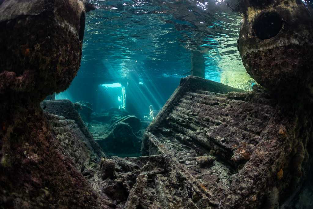Wreck interior framed by encrusted structures, light rays in distance, SS Sapona wreck, Bimini, Bahamas