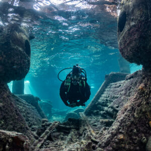 Diver facing the camera between massive encrusted wreck walls, SS Sapona wreck, Bimini, Bahamas