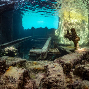 Interior of a shallow wreck with encrusted beams and sunlit opening, SS Sapona wreck, Bimini, Bahamas