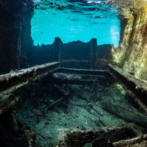 Collapsed beams inside a wreck hold under a bright surface window, SS Sapona wreck, Bimini, Bahamas