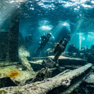 Vue verticale de plongeurs explorant les poutres d’une épave dans les rayons du soleil, épave du SS Sapona, Bimini, Bahamas