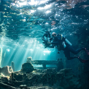 Underwater photographer with camera rig inside a sunlit wreck, SS Sapona wreck, Bimini, Bahamas