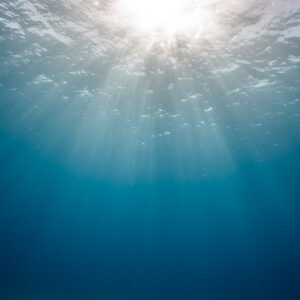 Sunburst and light rays under the surface in deep blue water, Bimini, Bahamas