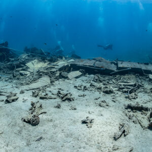 Scattered wreckage and hull plates of a broken wreck on white sand, Shaab Marsa Alam, Red Sea, Egypt