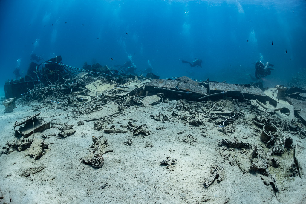 Scattered wreckage and hull plates of a broken wreck on white sand, Shaab Marsa Alam, Red Sea, Egypt