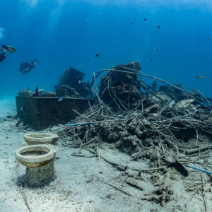 Diver above a tangle of cables and toilet bowls on a broken wreck, Shaab Marsa Alam, Red Sea, Egypt