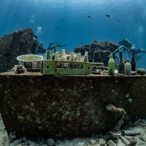 Vieilles bouteilles alignées sur une cuve rouillée d’une épave disloquée, Shaab Marsa Alam, mer Rouge, Égypte