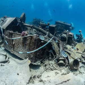 Rusted engine and machinery lying on sand among wreck debris, Shaab Marsa Alam, Red Sea, Egypt