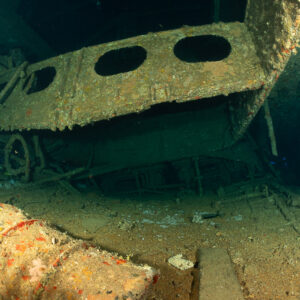Rusted barrels and portholed beams inside a wreck hold, Levanzo wreck, Red Sea, Egypt
