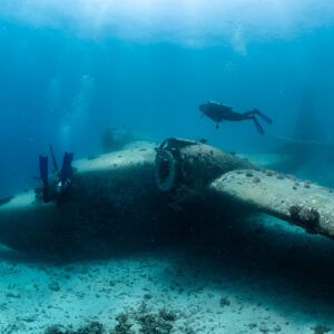 Seaplane wreck lying on sand with divers above the wing, Grumman HU-16 Albatross wreck, Red Sea, Egypt
