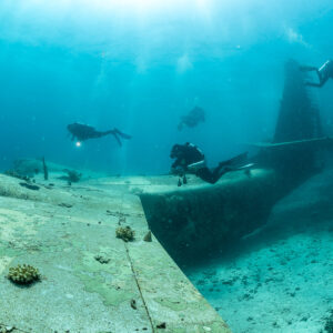 Divers along the wing and tail of a seaplane wreck, Grumman HU-16 Albatross wreck, Red Sea, Egypt