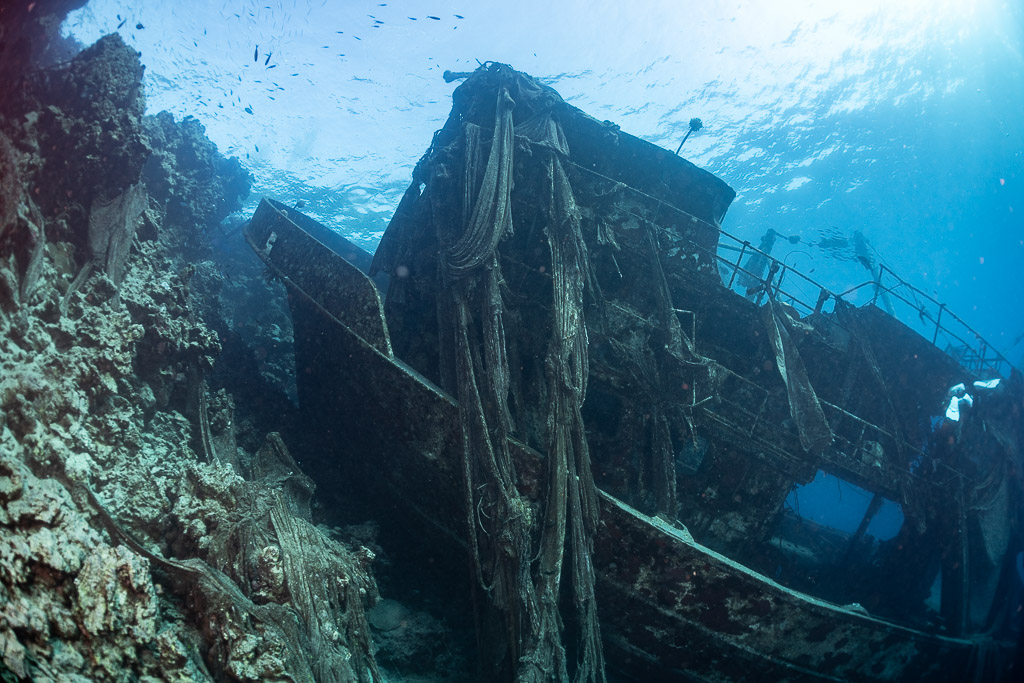 Net-draped bridge of a wreck lying against a reef, Sabri Baba 1 wreck, Red Sea, Egypt