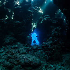 Silhouette de plongeur dans une fenêtre bleue au fond de la grotte, vertical, Shaab Claudio, mer Rouge, Égypte