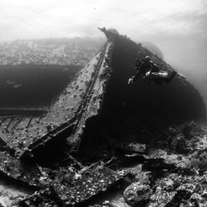 Coque d’épave montant vers la surface avec plongeur, noir et blanc, épave de l'Al Kahfain, mer Rouge, Égypte