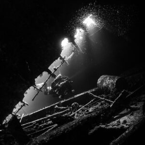 Black-and-white light beams falling into the dark wreck, Al Kahfain wreck, Red Sea, Egypt
