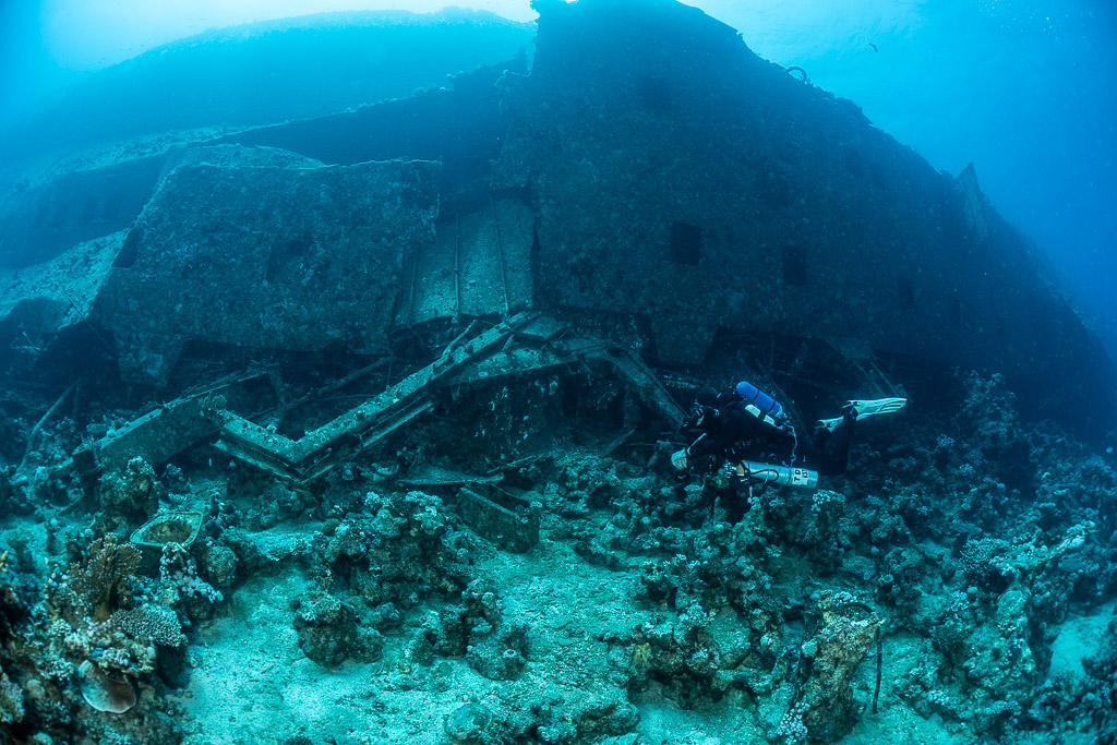 Diver along collapsed wreckage at the foot of the hull, Al Kahfain wreck, Red Sea, Egypt
