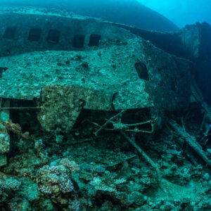 Vue large du flanc de l’épave avec fenêtres et petit plongeur, épave de l'Al Kahfain, mer Rouge, Égypte