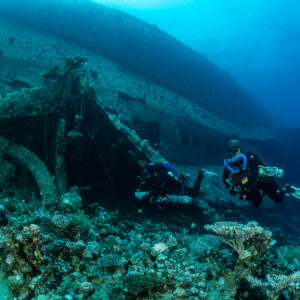 Two rebreather divers beside a broken section of the wreck, Al Kahfain wreck, Red Sea, Egypt