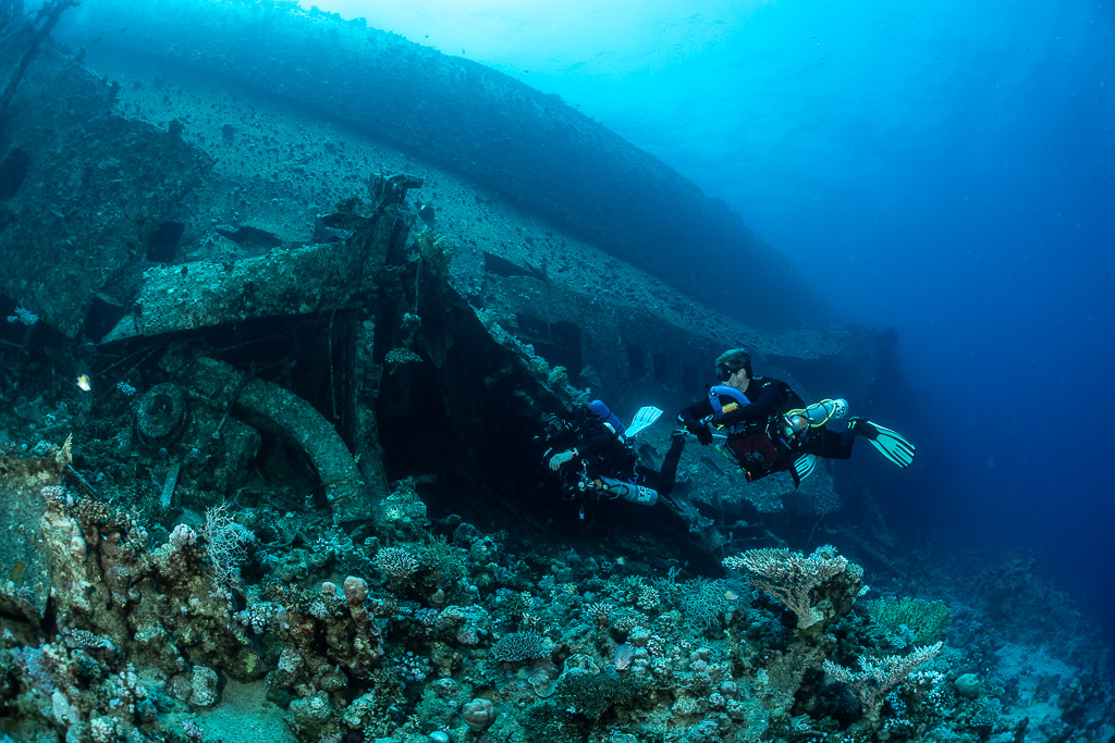 Two divers exploring the collapsed wreck section, wide view, Al Kahfain wreck, Red Sea, Egypt