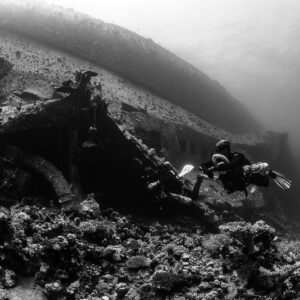 Black-and-white pair of divers at a collapsed wreck section, Al Kahfain wreck, Red Sea, Egypt