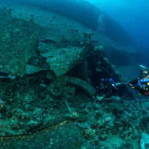 Two rebreather divers rising beside the broken wreck section, Al Kahfain wreck, Red Sea, Egypt