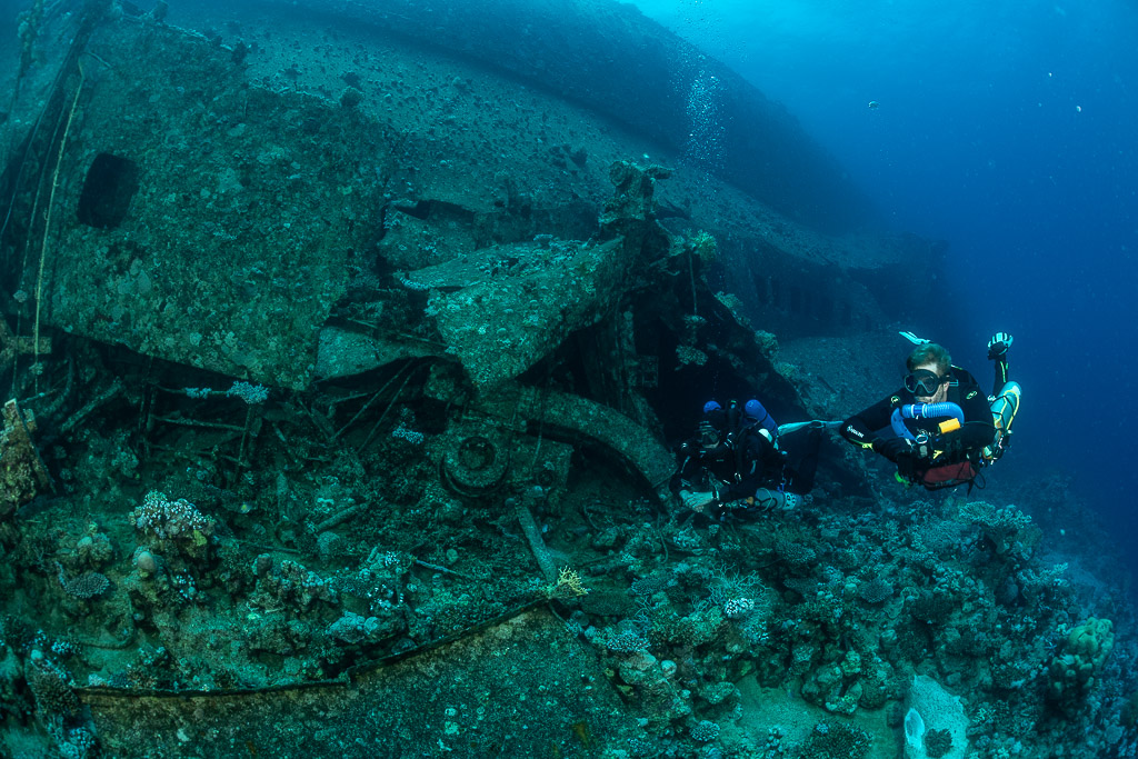Two rebreather divers rising beside the broken wreck section, Al Kahfain wreck, Red Sea, Egypt