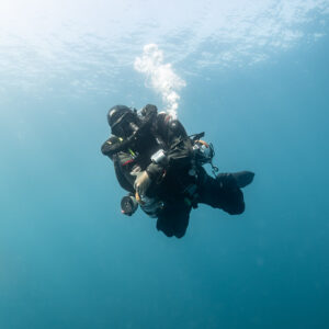 Rebreather diver in blue water with bubbles rising to the surface, Chalutier à Benoît wreck (Lacanau), Gironde, France